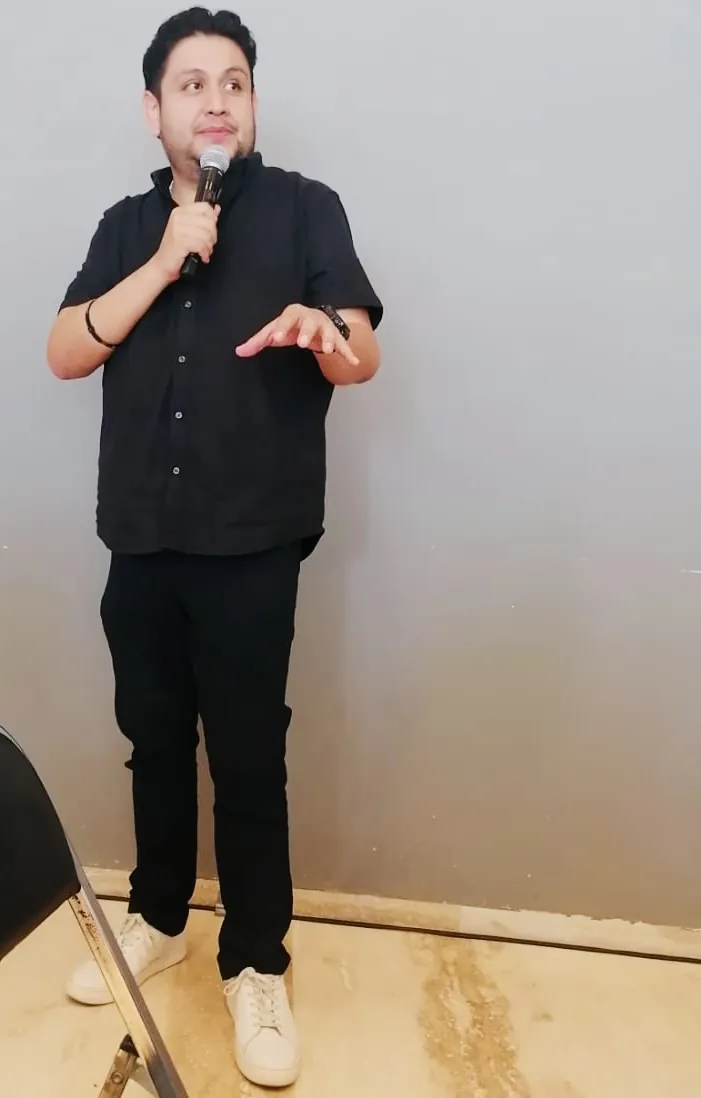 Joel dando una conferencia con micrófono